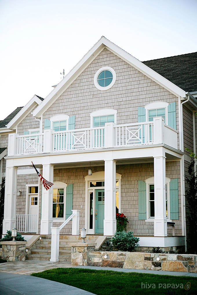 A coastal home with gray shake shingles and front door and shutters painted Benjamin Moore Wythe Blue, one of the best coastal paint colors!