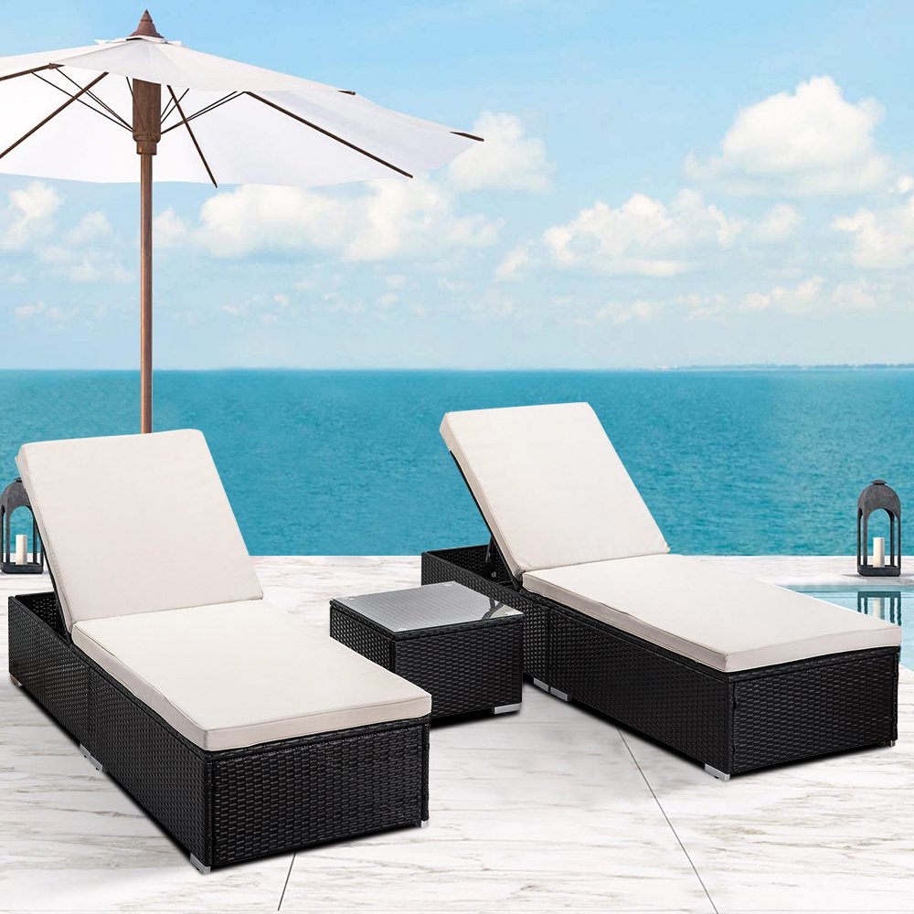 Affordable set of pool chaise lounge chairs and a side table with a dark brown wicker frame and beige cushions.