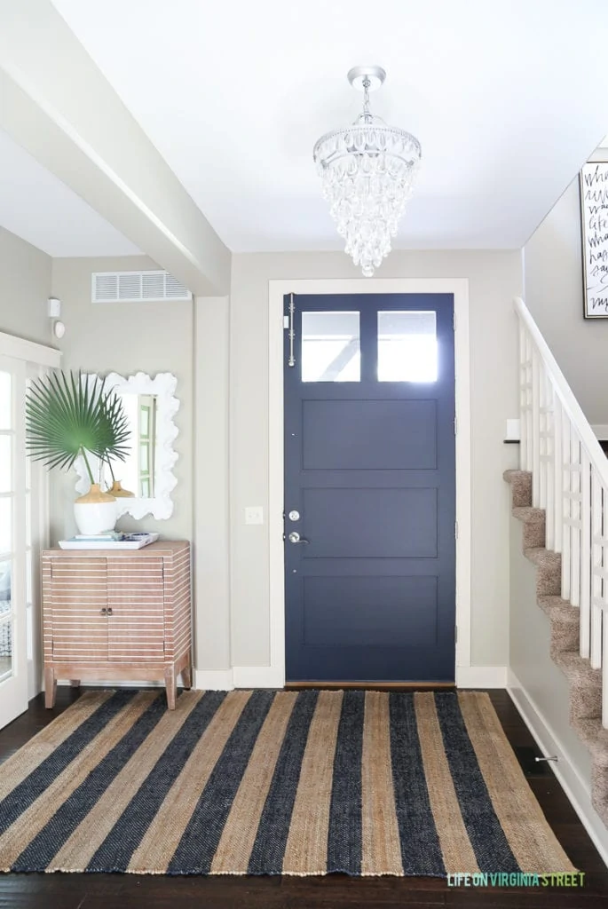 Behr Castle Path walls paired with a Benjamin Moore Hale Navy front door.