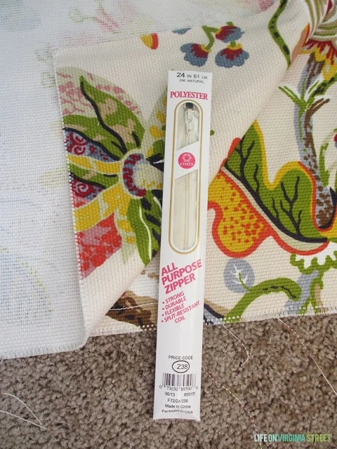 A zipper in its packaging beside the fabric.